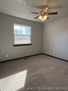 carpeted spare room with ceiling fan