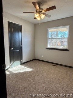 carpeted spare room featuring ceiling fan