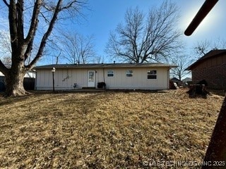 rear view of property featuring a lawn