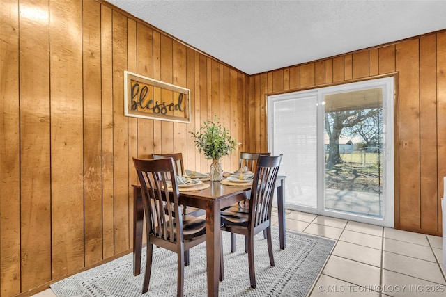 tiled dining area featuring wooden walls