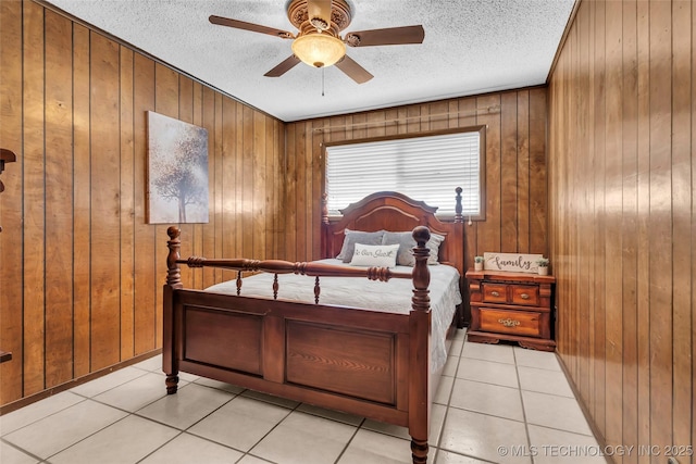 tiled bedroom with ceiling fan, wooden walls, and a textured ceiling