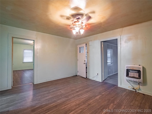 empty room featuring ceiling fan, dark hardwood / wood-style flooring, and heating unit