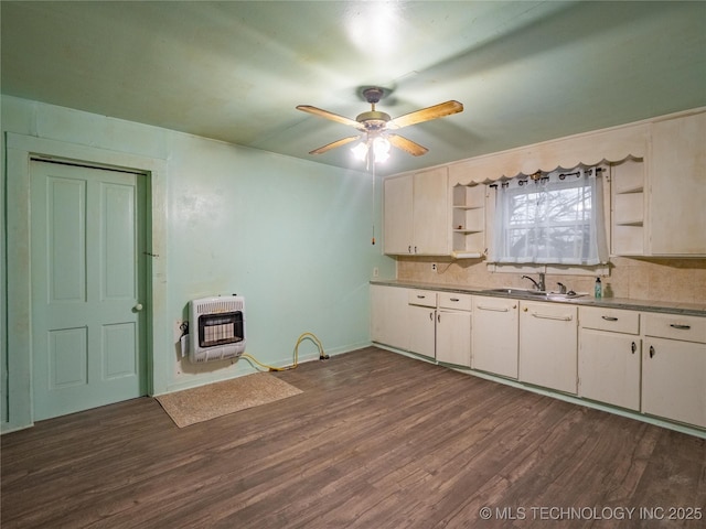 kitchen featuring sink, heating unit, white cabinets, and dark hardwood / wood-style flooring