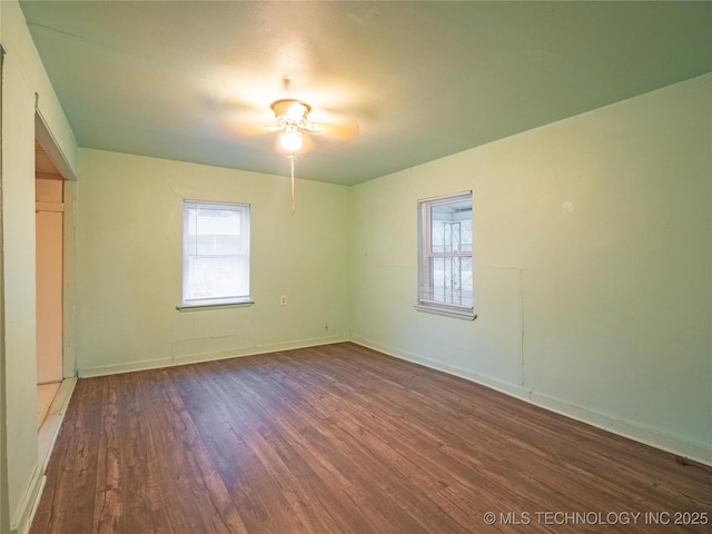 empty room with dark hardwood / wood-style flooring and a wealth of natural light