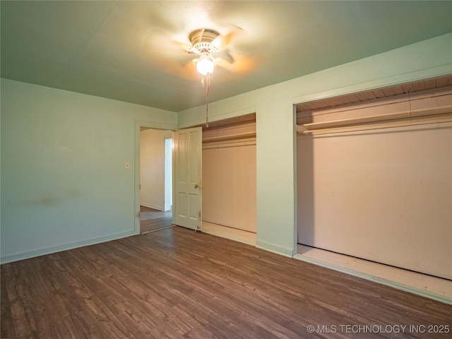 unfurnished bedroom with multiple closets and wood-type flooring