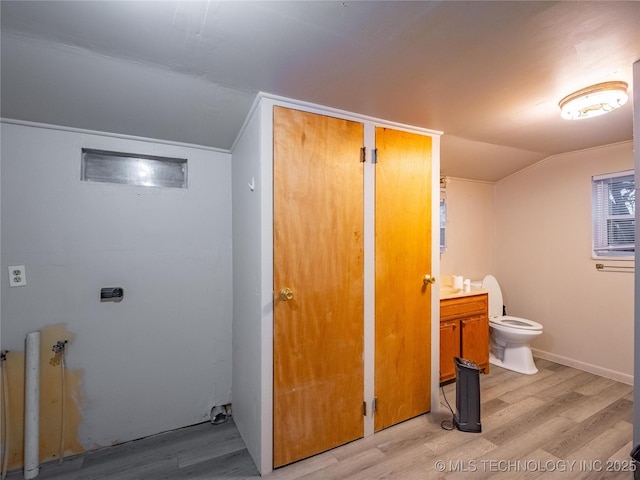 bathroom with vanity, hardwood / wood-style flooring, vaulted ceiling, and toilet