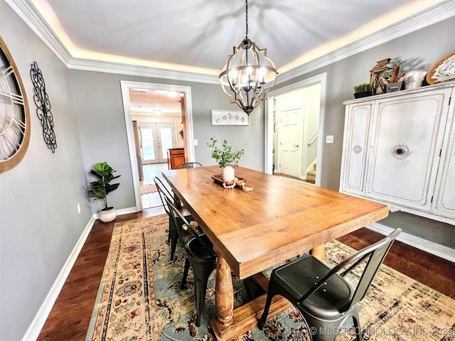 dining area with crown molding, dark wood-type flooring, a notable chandelier, and french doors