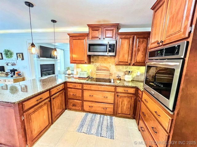 kitchen with hanging light fixtures, kitchen peninsula, stone counters, stainless steel appliances, and decorative backsplash