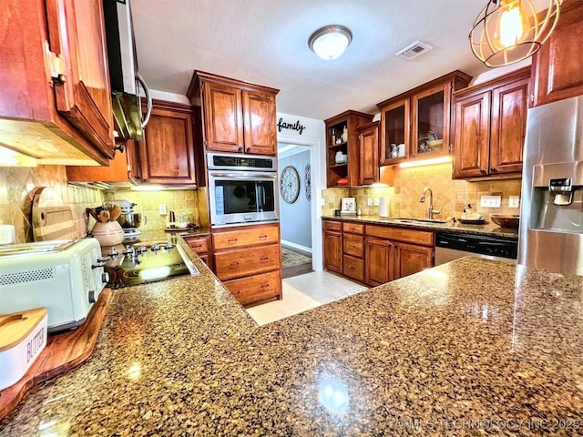 kitchen featuring light tile patterned flooring, appliances with stainless steel finishes, tasteful backsplash, sink, and hanging light fixtures