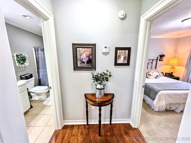 hallway with crown molding and light tile patterned flooring