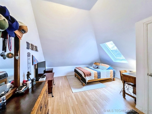 bedroom with hardwood / wood-style floors and lofted ceiling with skylight