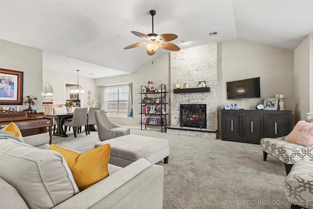 living room featuring ceiling fan with notable chandelier, lofted ceiling, light colored carpet, and a fireplace