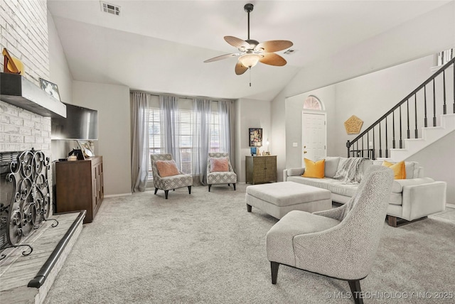 carpeted living room featuring ceiling fan, vaulted ceiling, and a brick fireplace