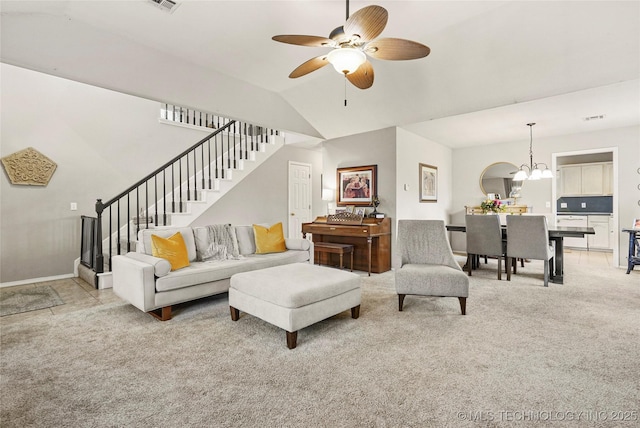 living room with ceiling fan with notable chandelier, vaulted ceiling, and light carpet