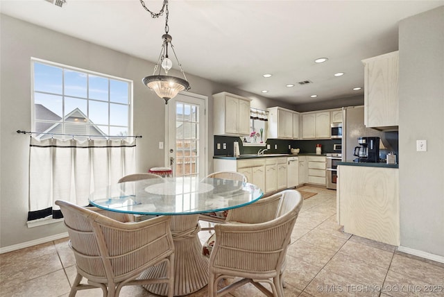 dining space featuring sink and light tile patterned floors