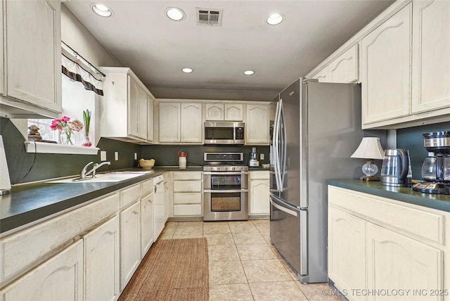 kitchen featuring light tile patterned flooring, appliances with stainless steel finishes, and sink