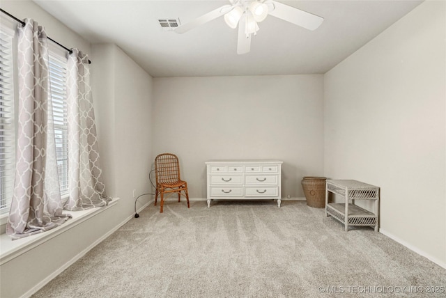 living area with light carpet and ceiling fan