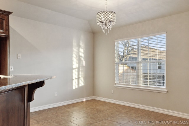 unfurnished dining area featuring light tile patterned flooring, plenty of natural light, sink, and a chandelier