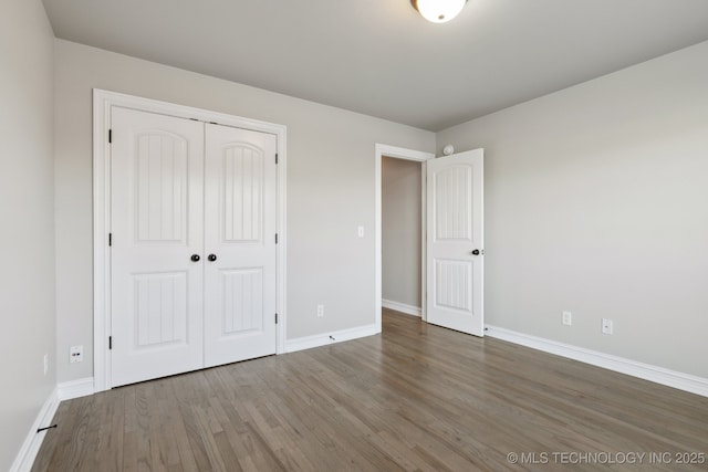 unfurnished bedroom with hardwood / wood-style floors and a closet