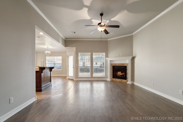 unfurnished living room with a tile fireplace, ornamental molding, dark hardwood / wood-style floors, and ceiling fan