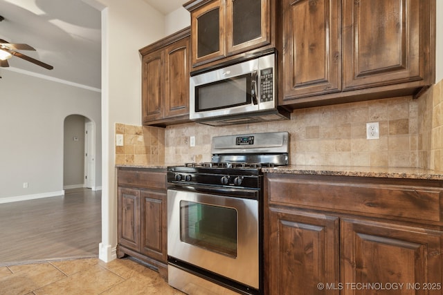 kitchen with light stone counters, appliances with stainless steel finishes, light tile patterned flooring, and decorative backsplash