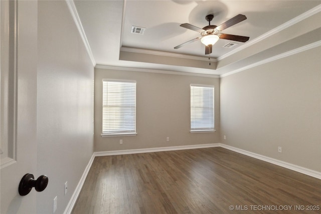 empty room with ceiling fan, ornamental molding, dark hardwood / wood-style floors, and a raised ceiling