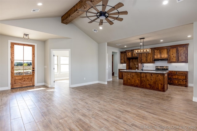 kitchen featuring an island with sink, ceiling fan, light hardwood / wood-style floors, and decorative light fixtures