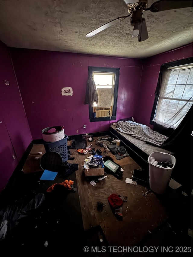 bedroom with ceiling fan and a textured ceiling