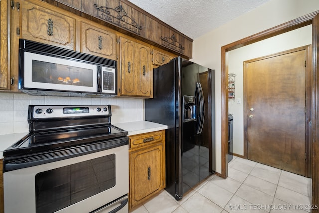 kitchen featuring light tile patterned flooring, appliances with stainless steel finishes, a textured ceiling, and backsplash