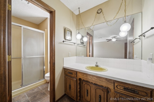 bathroom with walk in shower, toilet, a textured ceiling, vanity, and ceiling fan