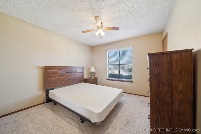 bedroom featuring light carpet, ceiling fan, and a textured ceiling