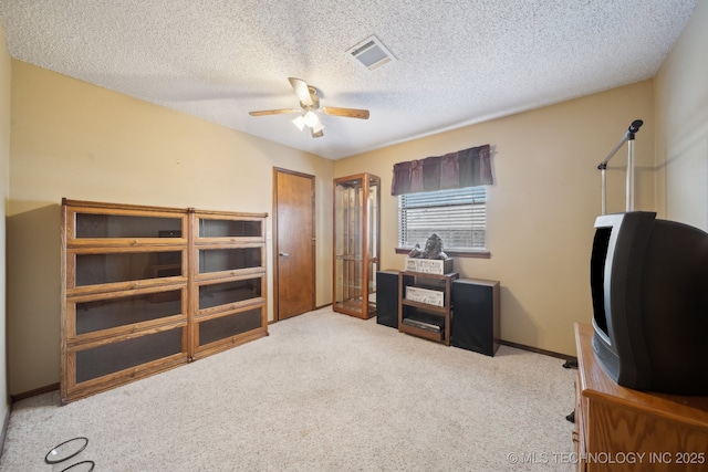 office space featuring light carpet, a textured ceiling, and ceiling fan