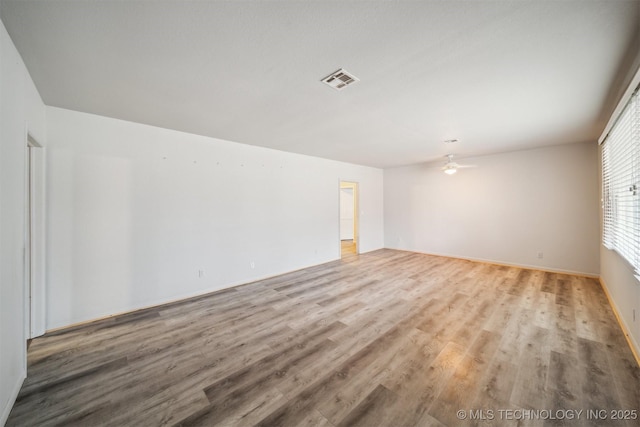 spare room with ceiling fan and light wood-type flooring