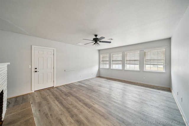 unfurnished living room with ceiling fan, light hardwood / wood-style floors, and a brick fireplace