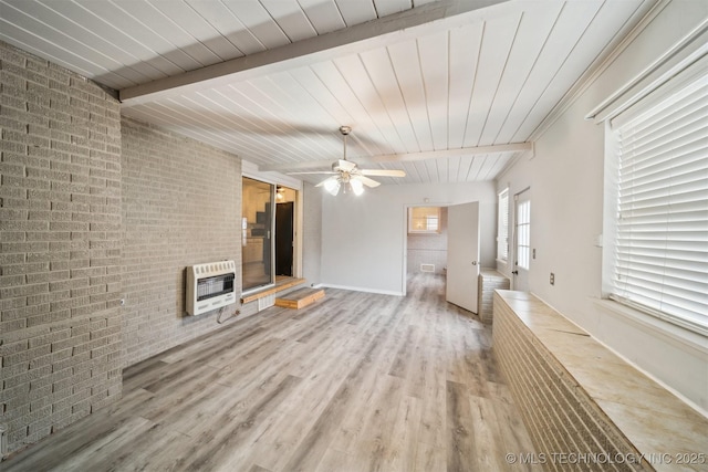 unfurnished living room featuring brick wall, beam ceiling, hardwood / wood-style floors, and heating unit