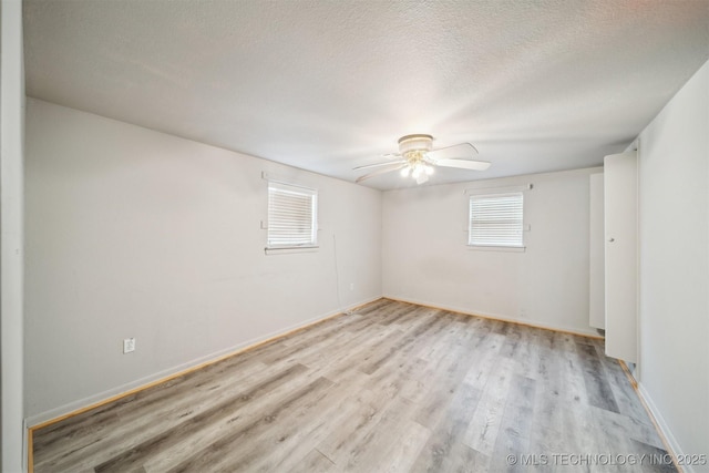 empty room featuring ceiling fan, light hardwood / wood-style floors, and a textured ceiling