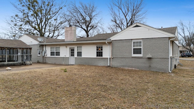 rear view of house featuring a yard, a patio area, and a sunroom