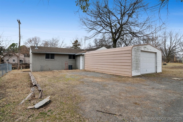 rear view of property featuring a garage and an outdoor structure