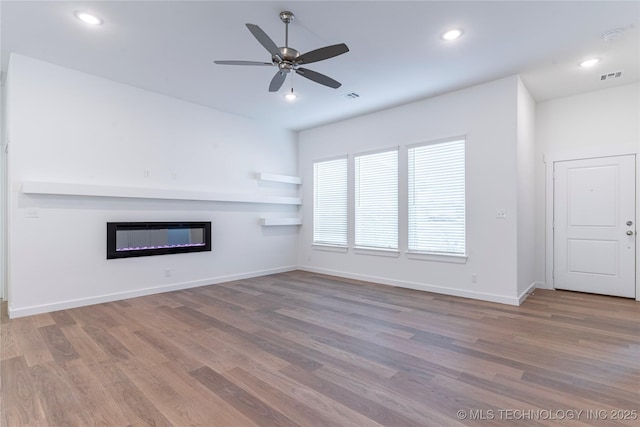 unfurnished living room with ceiling fan and wood-type flooring