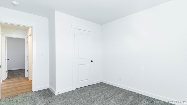 unfurnished bedroom with dark colored carpet