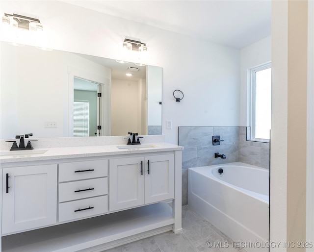 bathroom featuring tile patterned floors, vanity, and a washtub