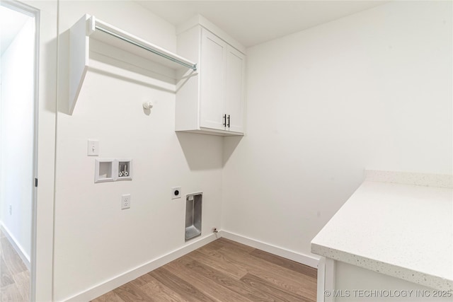 laundry room with gas dryer hookup, cabinets, light hardwood / wood-style flooring, washer hookup, and hookup for an electric dryer