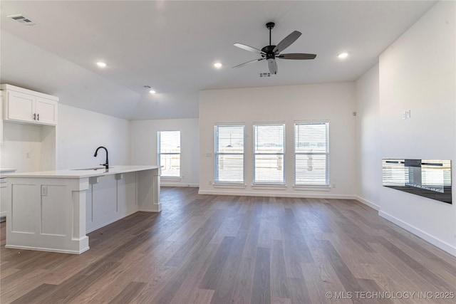 kitchen featuring a kitchen island with sink, sink, white cabinetry, and dark hardwood / wood-style floors