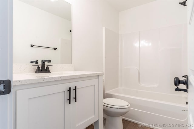 full bathroom featuring shower / bath combination, vanity, hardwood / wood-style floors, and toilet