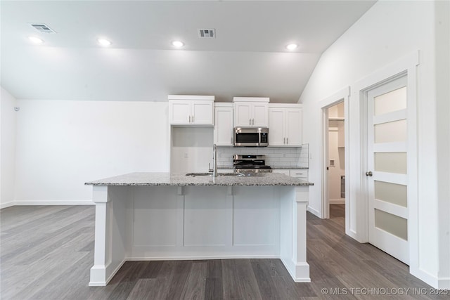 kitchen with sink, white cabinetry, light stone counters, an island with sink, and stainless steel appliances