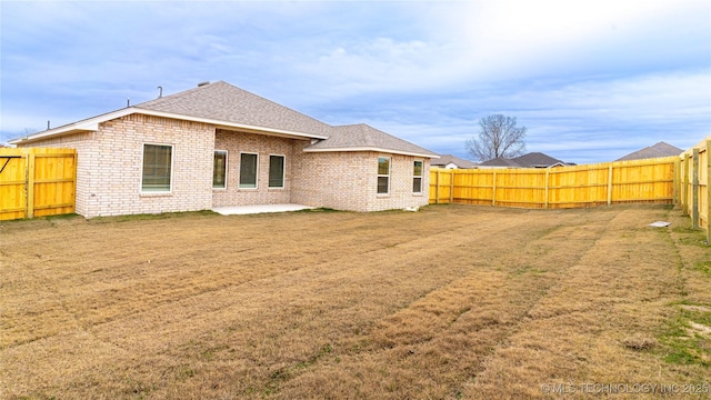 rear view of house with a lawn and a patio area