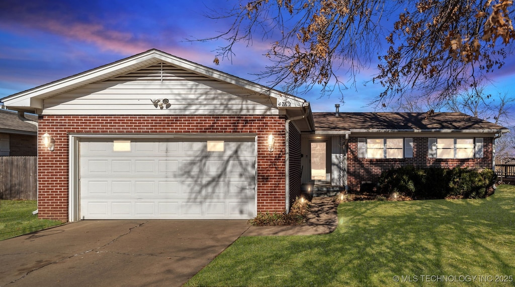 ranch-style house with a garage and a lawn