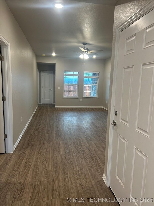 interior space with dark wood-type flooring and ceiling fan