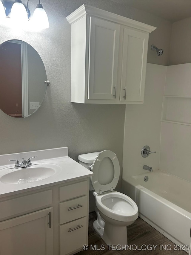 full bathroom featuring hardwood / wood-style flooring, shower / washtub combination, vanity, and toilet