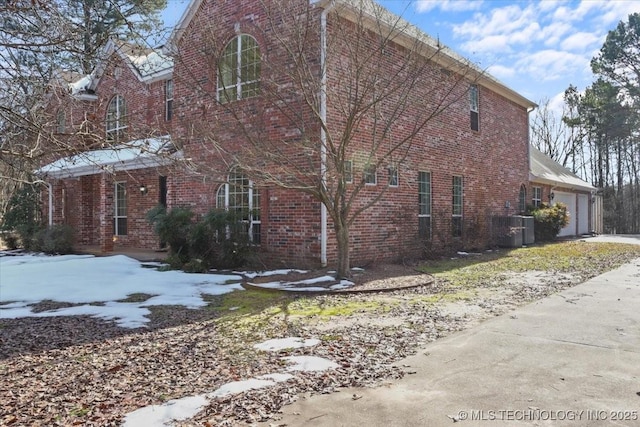 view of side of home with a garage and central AC